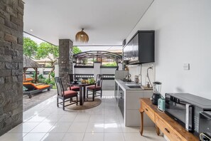 A modern kitchen with a built-in oven, a microwave, and a coffee maker. - Sunbeji Villa (Seminyak)