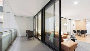 Un intérieur moderne avec une cloison en verre, un canapé, une table à manger et une chaise.