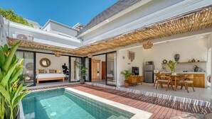 Een modern huis met een zwembad, een eethoek en een slaapkamer met een groot bed.