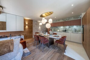 A modern kitchen with a dining area, wooden accents, and a stone backsplash. - ETOILES DU LINGA  - A22 (CHATEL)