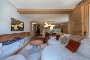 Ein modernes Interieur mit Kamin, Essbereich und Wohnzimmer mit Sofa und Sesseln.