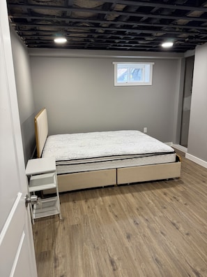 Ein Schlafzimmer mit einem Bett, einem Fenster und Holzboden.