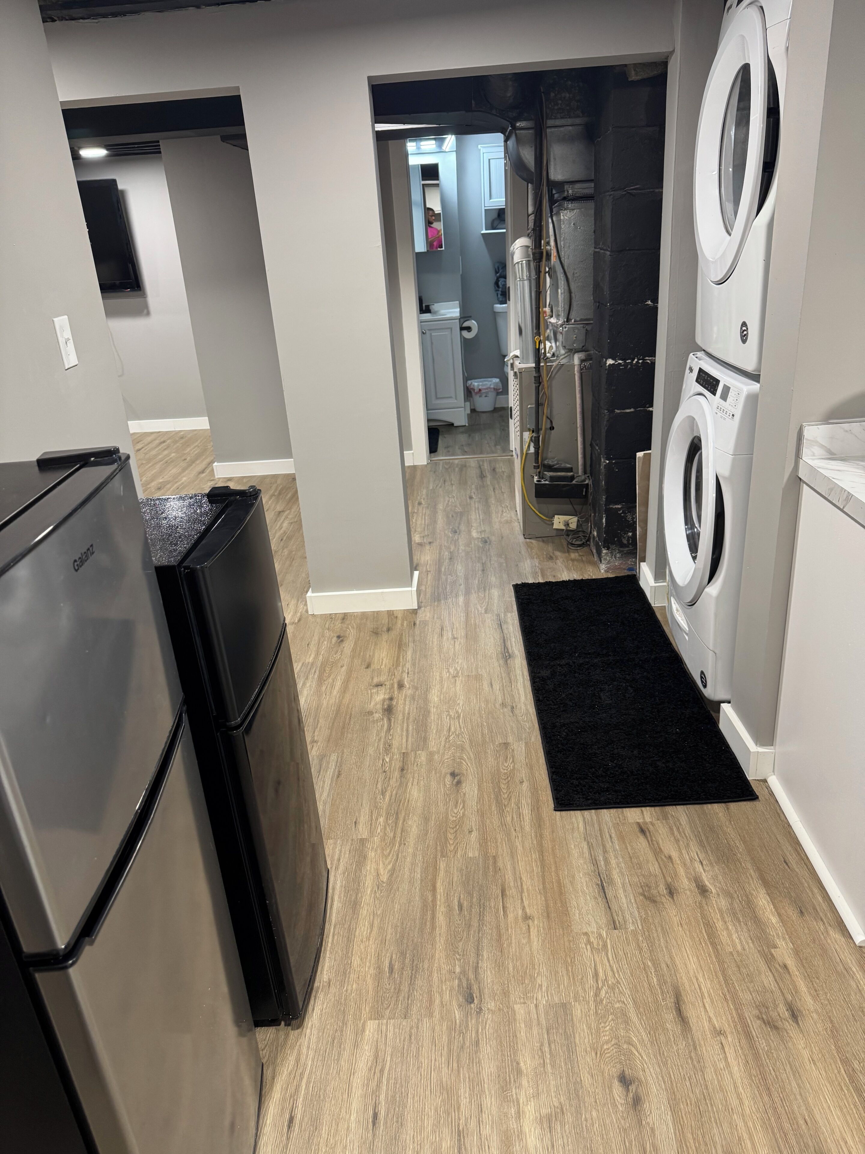 A laundry room with a washing machine, a dryer, and a refrigerator.