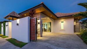 A modern house with a tiled roof, a covered entrance, and a well-lit interior. - Orchid Paradise Homes OPV422 (Hin Lek Fai)