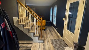 Una escalera con barandillas de madera y peldaños alfombrados que lleva a una plataforma.