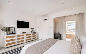 A bedroom with a bed, a white dresser, a flat-screen TV, and a window with curtains. - Stylish Chelsea Home Amazing Location (London)