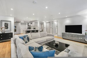 Ein modernes Wohnzimmer mit einer Couch, einem Couchtisch und einem Fernseher.