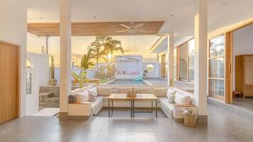 Uma sala de estar ampla com piscina, assentos confortáveis e ventilador de teto.