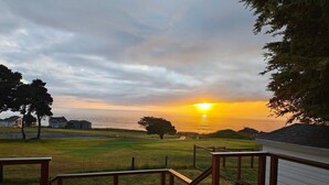 Una coberta de fusta amb vista al sol que es pon sobre l'oceà.