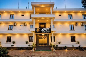 A hotel with a modern design, featuring a prominent entrance, multiple floors, and a signboard. - Hotel JK Blue Heaven (Varanasi)