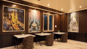 Uma sala de conferências com painéis de madeira, grandes obras de arte emolduradas e piso de mármore.