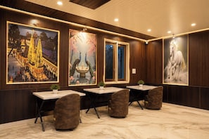 A conference room with wooden paneling, large framed artworks, and a marble floor. - Hotel JK Blue Heaven (Varanasi)