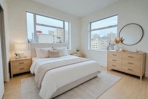 A bedroom with a bed, two nightstands, a dresser, and large windows. - Spectacular penthouse in a modernist, boutique concrete-and-glass building (Vancouver)