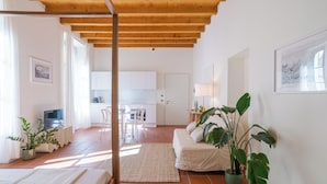 Un interior moderno con techo de madera, una cama, un sofá, un comedor y una cocina.