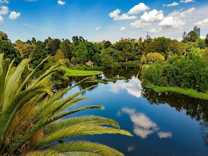 A serene lake with lush greenery and a small building in the background. - Bright 1-Bed Stay Near Crown Melbourne (South Melbourne)