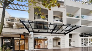 En bygning med flere etager, et glaskuppel, butikker i stueplan og altaner på hver etage.