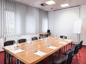 A conference room with a long table, chairs, a whiteboard, and a radiator. - 1 Person Holiday Park Home in Brauschweig (Braunschweig)