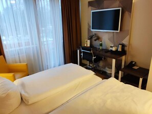 A hotel room with a bed, a desk with a computer, a chair, and a TV. - 1 Person Holiday Park Home in Brauschweig (Braunschweig)