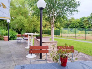 An outdoor patio area with benches, tables, and potted plants. - 1 Person Holiday Park Home in Brauschweig (Braunschweig)