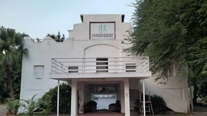 Un edificio con un letrero que dice 'UNWIND RESORT' y un balcón.