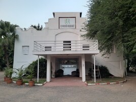 Um edifício com uma placa que diz 'UNWIND RESORT' e uma varanda.