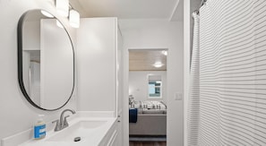 A bathroom with a sink, mirror, and towel rack.