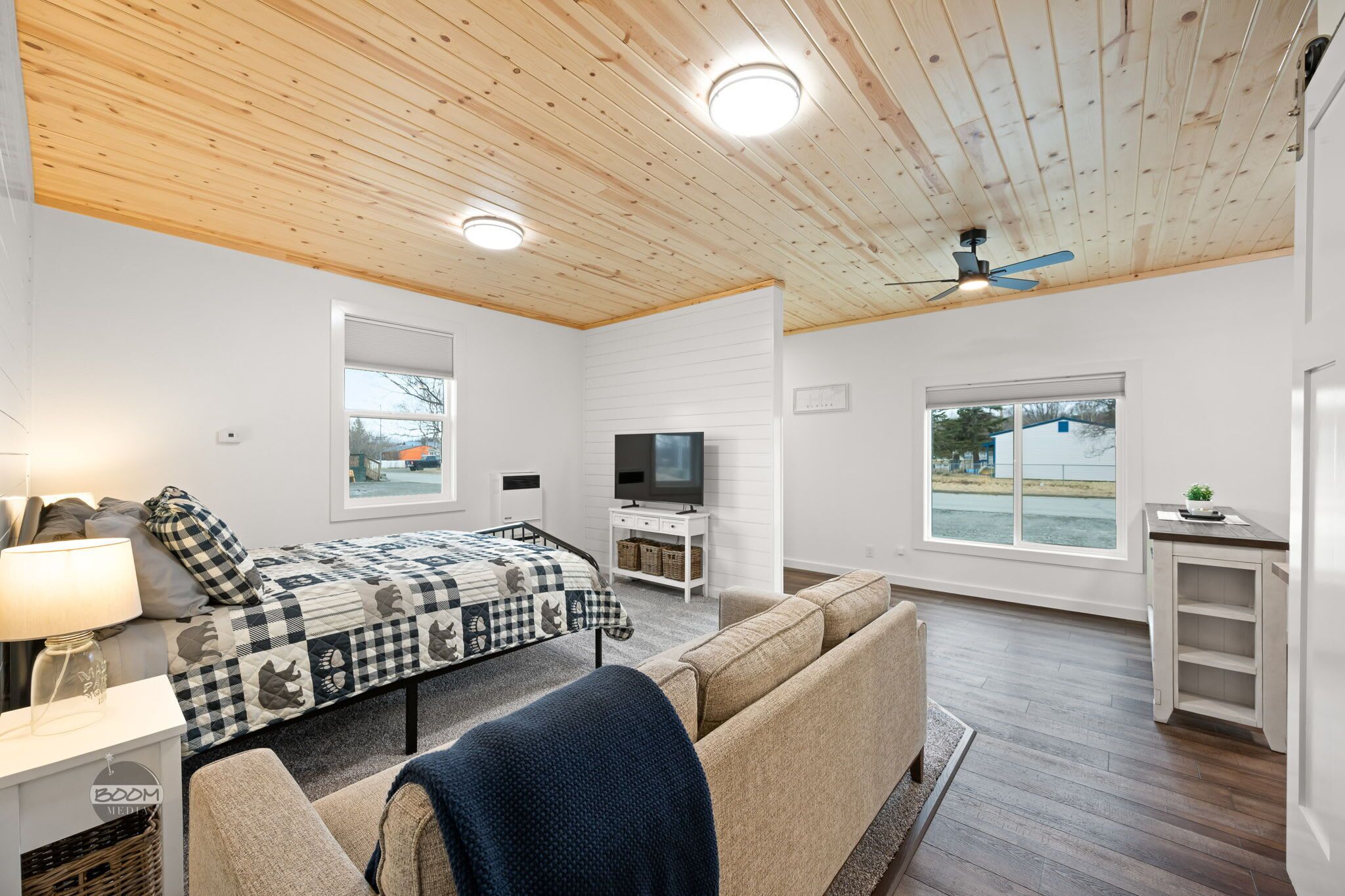 Une chambre avec un lit, un canapé, une télévision et une fenêtre donnant sur un beau paysage.