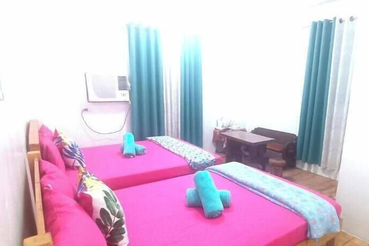 A room with two beds, a desk, and a chair.