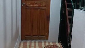 Una puerta de madera, un suelo a rayas y una alfombra pequeña.