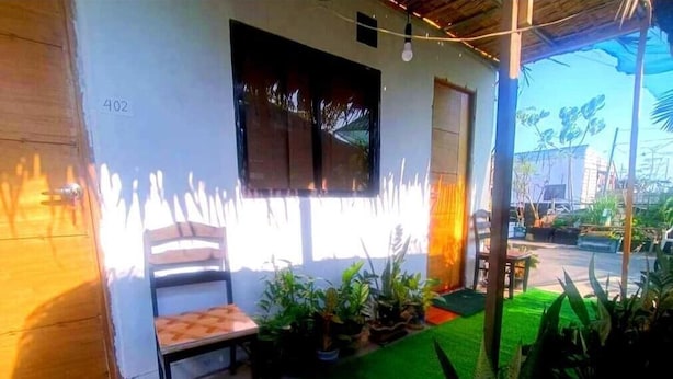 Una habitación con una silla, una mesita y una ventana.