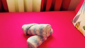 Una cama con un colchón rojo y una manta enrollada.
