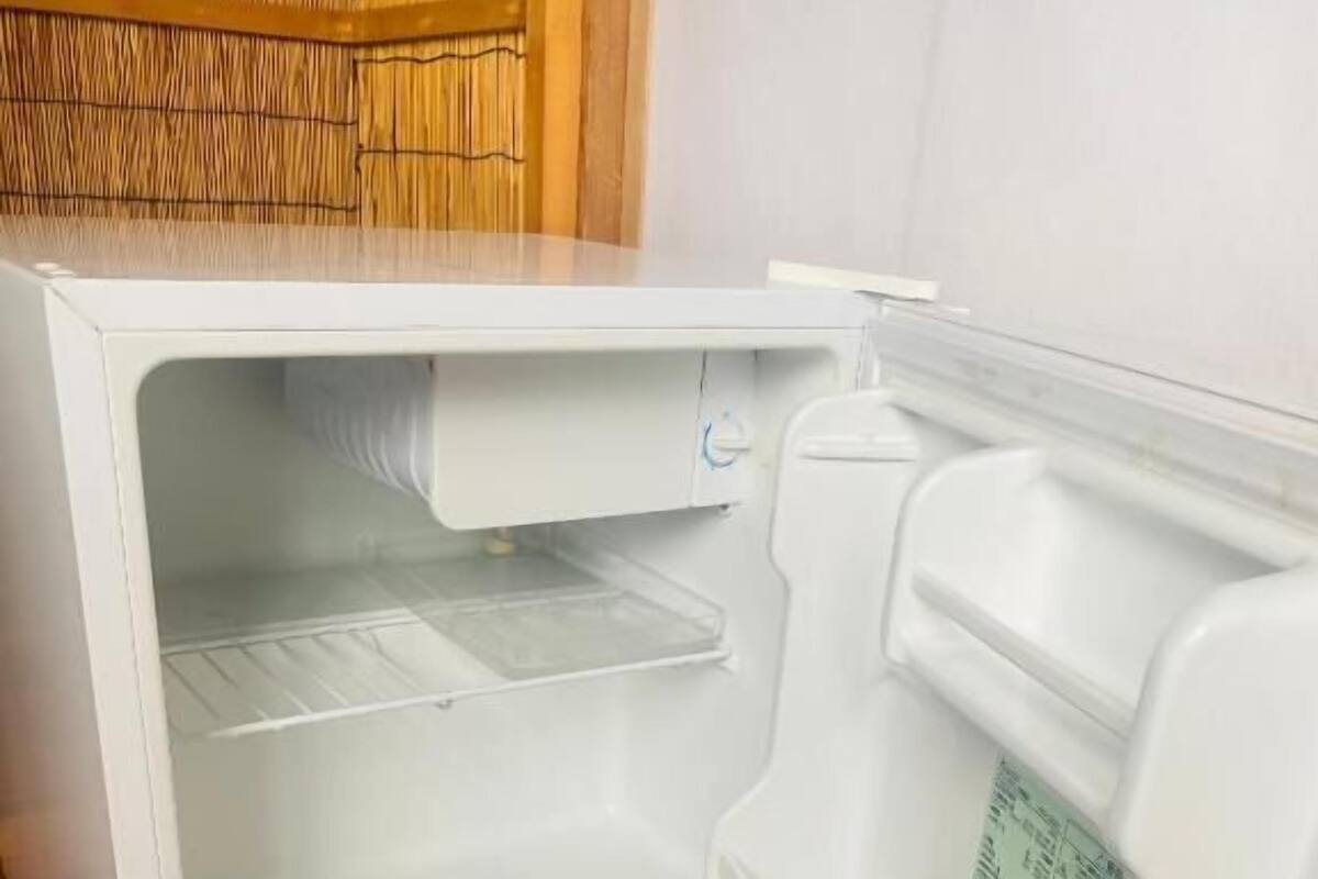 A white refrigerator with a freezer compartment, a control panel, and a water dispenser.