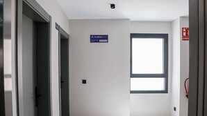Un couloir avec une pancarte indiquant « Étage 2 » et un panneau de sortie.