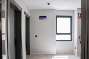 Un pasillo con un cartel que indica 'Planta 2' y una señal de salida.