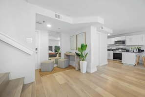 Ein modernes Apartment mit Küche, Essbereich und einer Treppe zu einer weiteren Ebene.