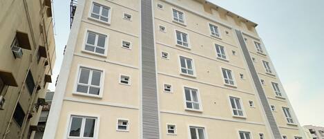Un edificio a più piani con un'area di parcheggio coperta antistante.