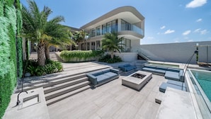 A modern building with a pool, outdoor seating, and a staircase leading to the entrance. - LegKo Villa (Pecatu)