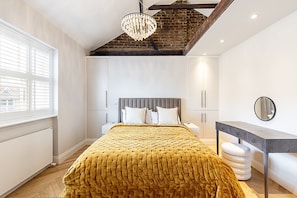 Ein Schlafzimmer mit Bett, Nachttisch, Kleiderschrank und einer Deckenleuchte.