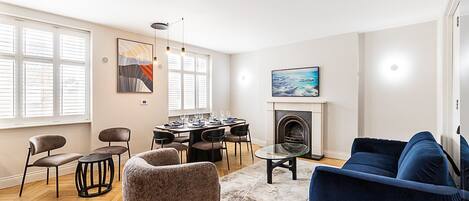Una sala de estar con chimenea, comedor y sofá.