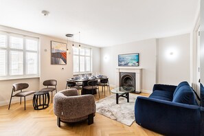 Ein Wohnzimmer mit Kamin, Essbereich und einer Couch.