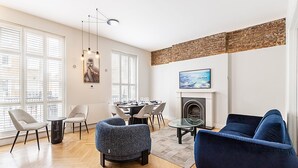Una sala de estar moderna con chimenea, comedor y ventanas grandes.