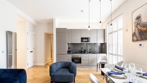 Una cocina moderna con gabinetes grises, protector contra salpicaduras negro y electrodomésticos de acero inoxidable.