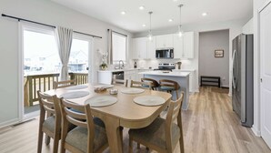 Una cocina moderna con armarios blancos, microondas y refrigerador.