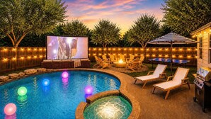 A backyard with a swimming pool, lounge chairs, a barbecue grill, and a projector screen. - Pool, Hot Tub, Huge Outdoor Theater, Mini Golf, Bowling, BBQ, Fire Pit,Sleeps 19 (Pflugerville)