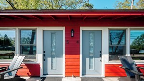 Un edificio con fachada roja y blanca, dos puertas y un pequeño ventanal.