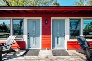 Ein Gebäude mit roter und weißer Fassade, zwei Türen und einem kleinen Fenster.
