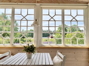 A wooden interior with large windows, a white table, and a bench. - Your cottage, more Swedish than Sweden (Ryd)