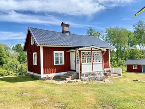 A red wooden house with a dark roof, white trim, and a stone foundation. - Your cottage, more Swedish than Sweden (Ryd)
