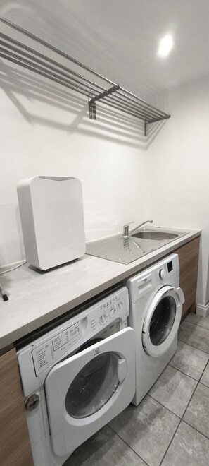 A laundry area with a washing machine, dryer, and sink.