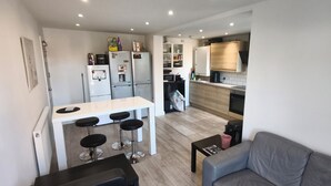 Una cocina compacta con comedor, un sofá y una pequeña mesa.
